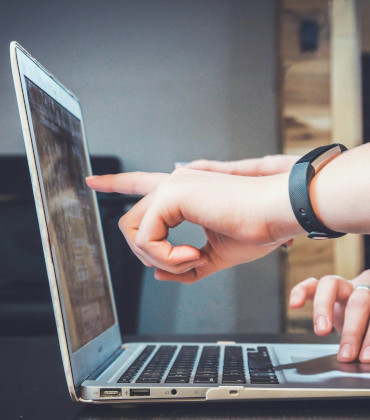 Someone pointing a computer screen to show something